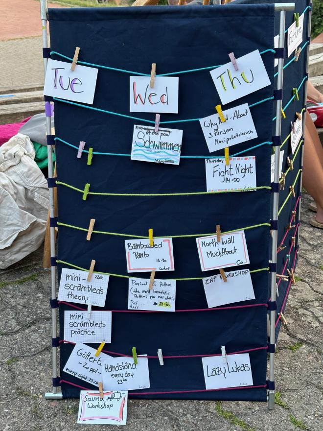 A board with cards hanging from strings, showing workshop titles