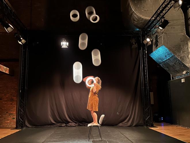 &ldquo;Kathrin Wagner juggling seven rings on a chair&rdquo;