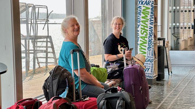 &ldquo;Karen and Maria sitting in a ferry terminal with luggage&rdquo;