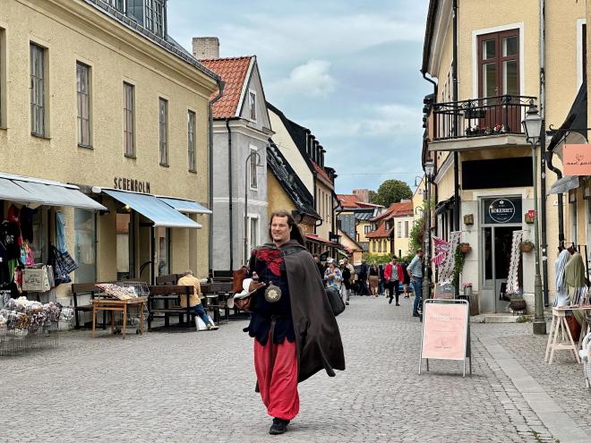 &ldquo;a medieval town street scape with a costumed pedestrian&rdquo;