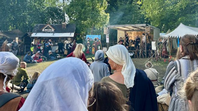 &ldquo;several food stalls and a rustic stage with musicians performing&rdquo;