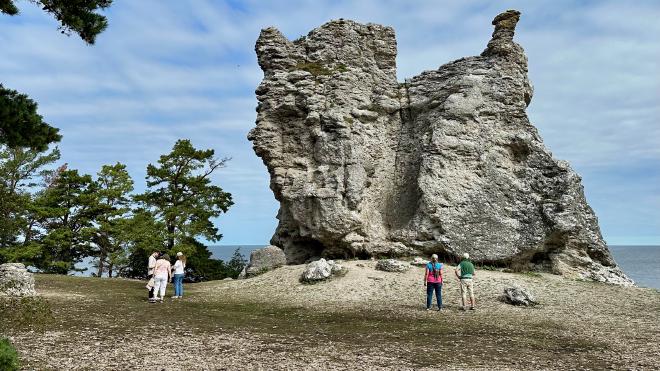&ldquo;five people standing in front of a very large rauk&rdquo;