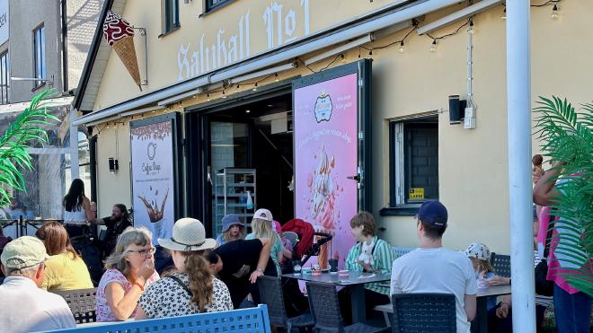 &ldquo;people eating ice cream outside an ice cream shop&rdquo;